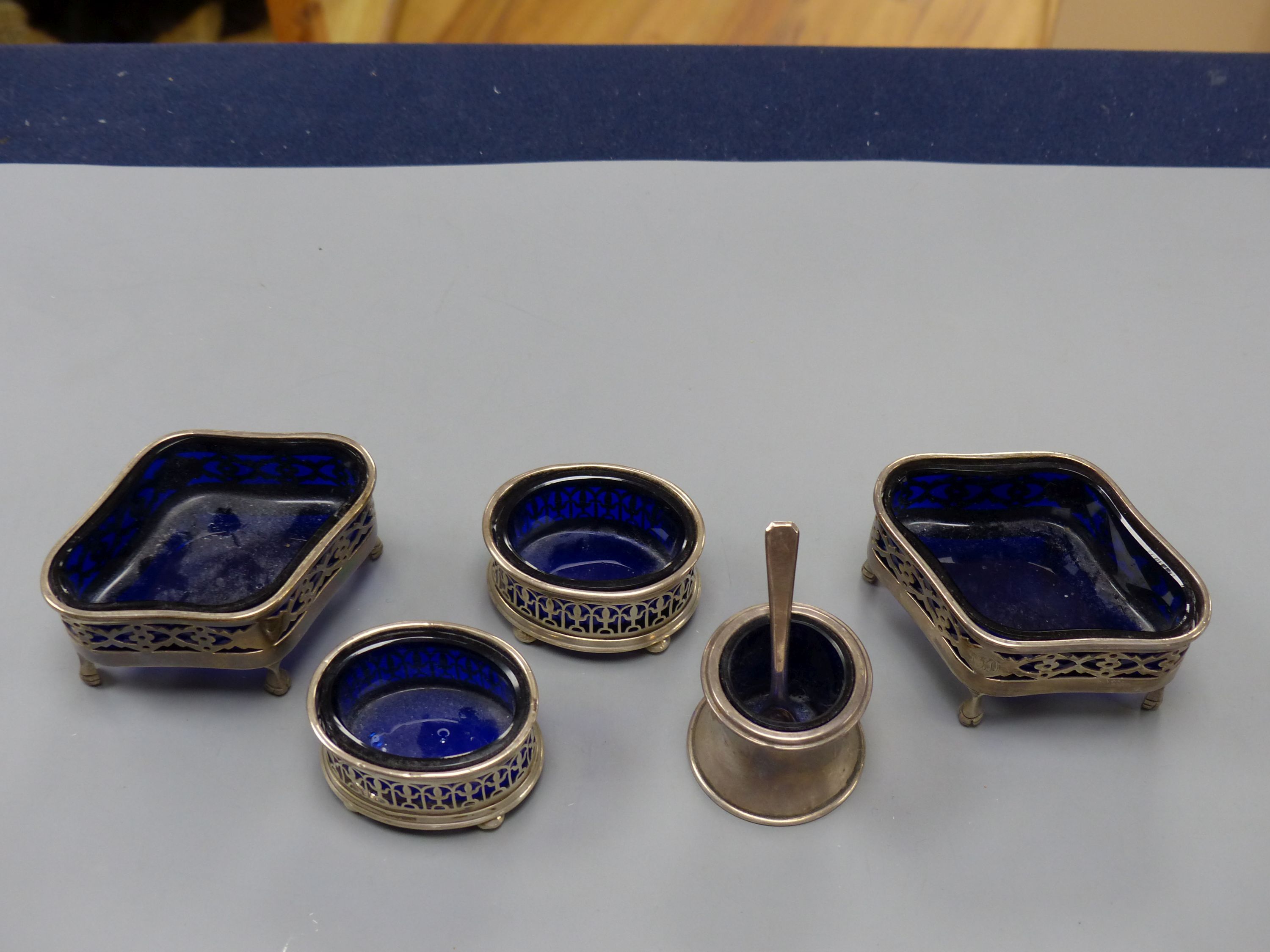 A pair of Edwardian pierced silver quatrefoil shaped salts with blue glass liners, London, 190987mm and three other smaller silver salts.
